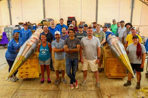 The Embry-Riddle and NASA field team with fully assembled, instrumented payloads for the SEED rockets within the Payload Assembly Tent on Kwajalein Atoll.