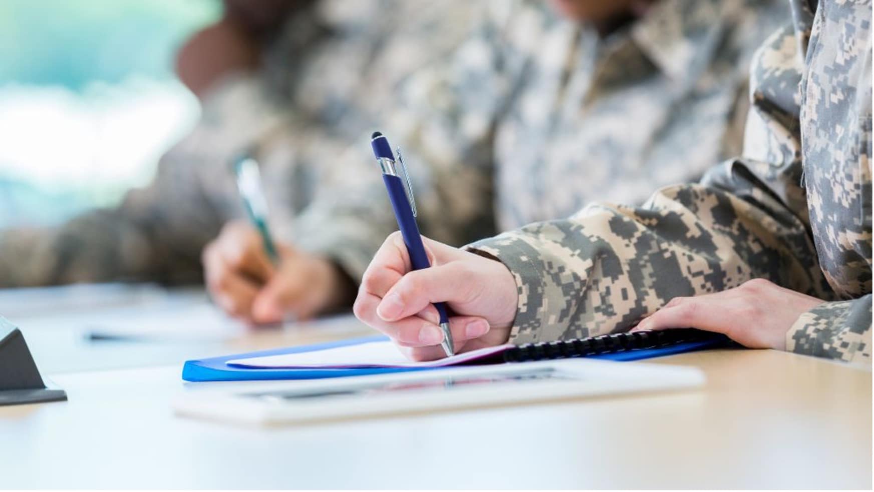 People in military uniforms writing on paper