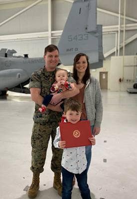 Taylor Johnson holds daughter Evelyn in front of a Marine Corps V-22 Osprey with his wife Rachel and son Daniel.