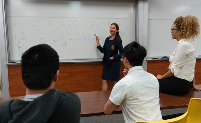 Dr. Katariina Nykyri presents at the whiteboard to Dr. Shiva Kavosi, Dr. Xuanye Ma and Ph.D. student Yulun Liou