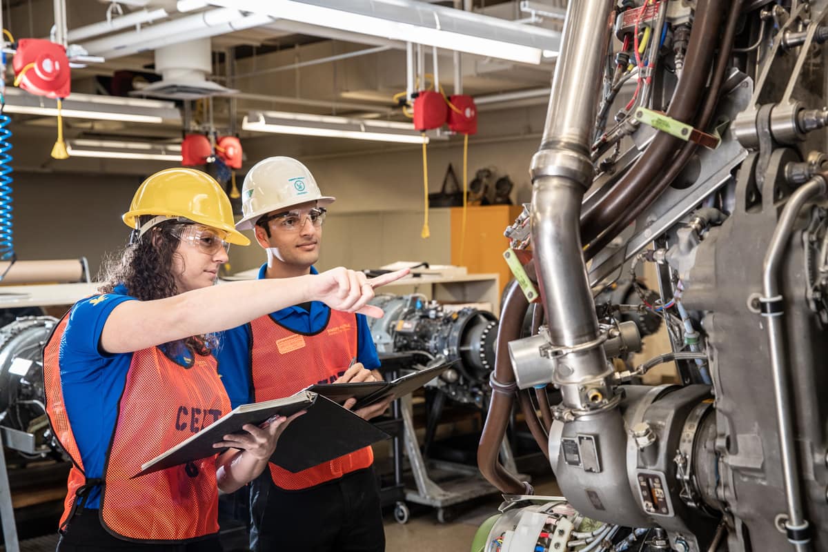 Engineers look at a machine.