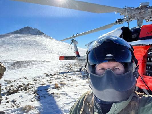 Rescuer on a mountain with helicopter.