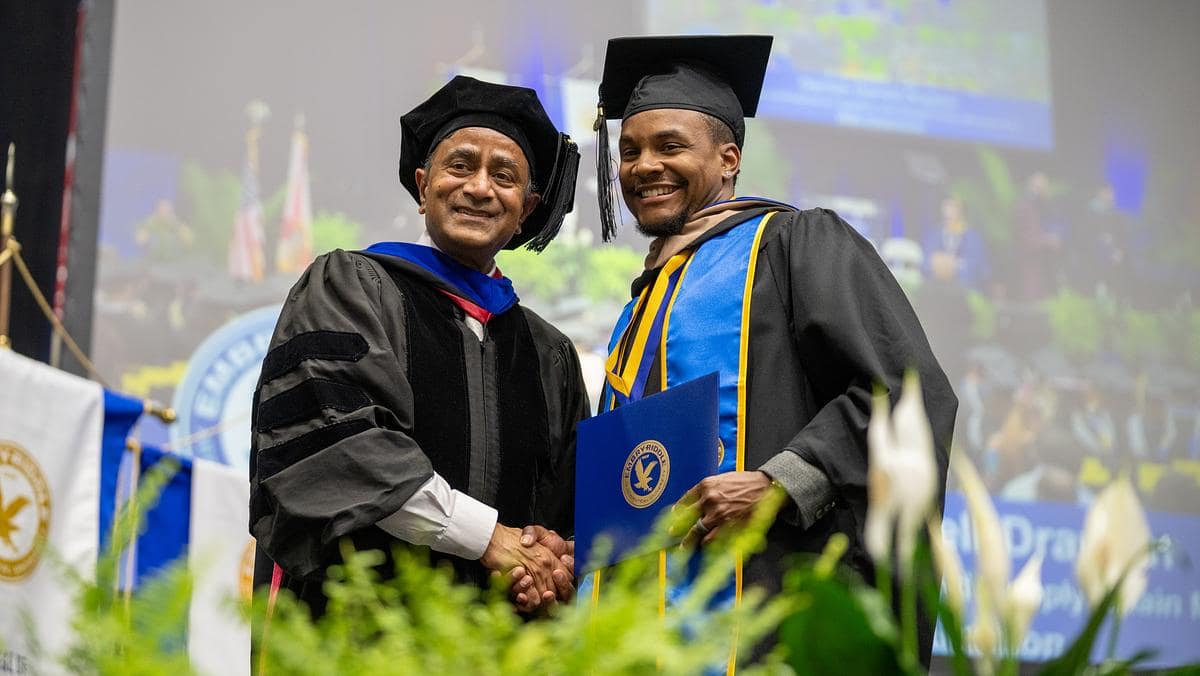 A student celebrates during Embry-Riddle Aeronautical University’s Worldwide Campus graduate hooding ceremony in 2023.