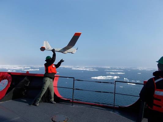 National Oceanographic and Atmospheric Administration scientist Kevin Vollbrecht launches a Puma uncrewed aerial vehicle from the bow of the Coast Guard Cutter Healy