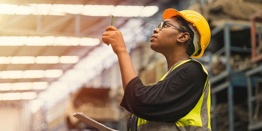 Black woman checking inventory in warehouse