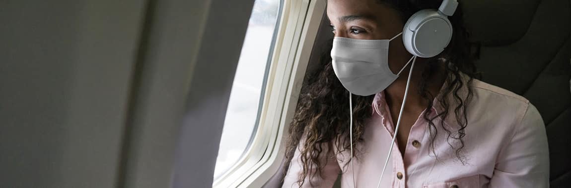 a woman on an airplane wearing a mask
