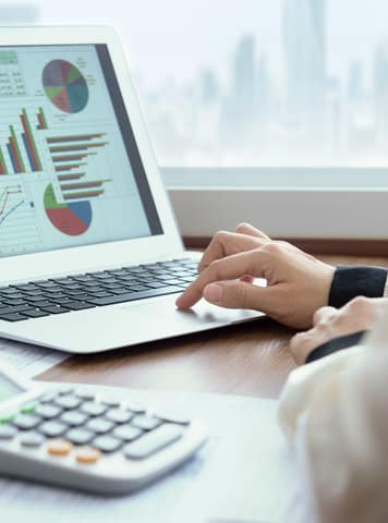 a man works on a laptop looking at data