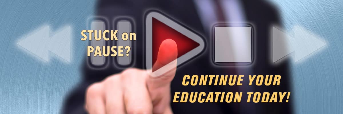 Suited man pressing play button to continue his education.