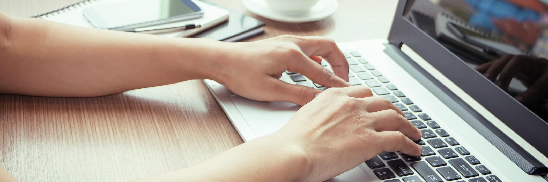 Hands typing on laptop