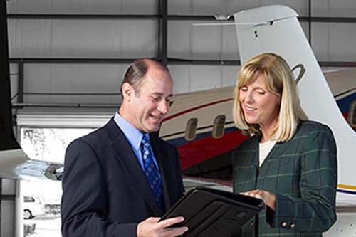 a man and a woman discuss something in a hangar